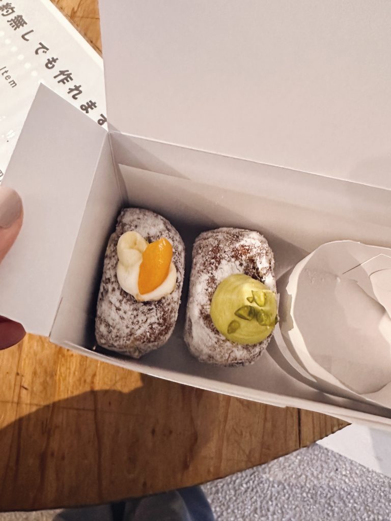 東京咖啡店外帶甜甜圈盒內的兩款甜甜圈，上方為開盒視角，呈現旅途中的甜點時