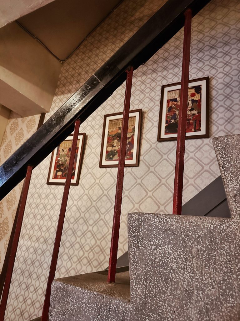 台北老宅咖啡 Futago Cafe 孵咖啡孵珈琲洋館的樓梯空間，復古壁紙與牆面裝飾畫展現老宅咖啡廳氛圍。